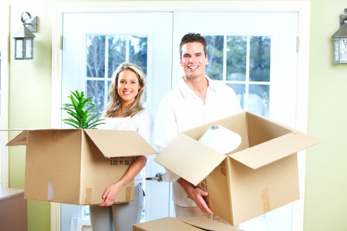 Packed moving boxes and furniture ready for collection in Bow